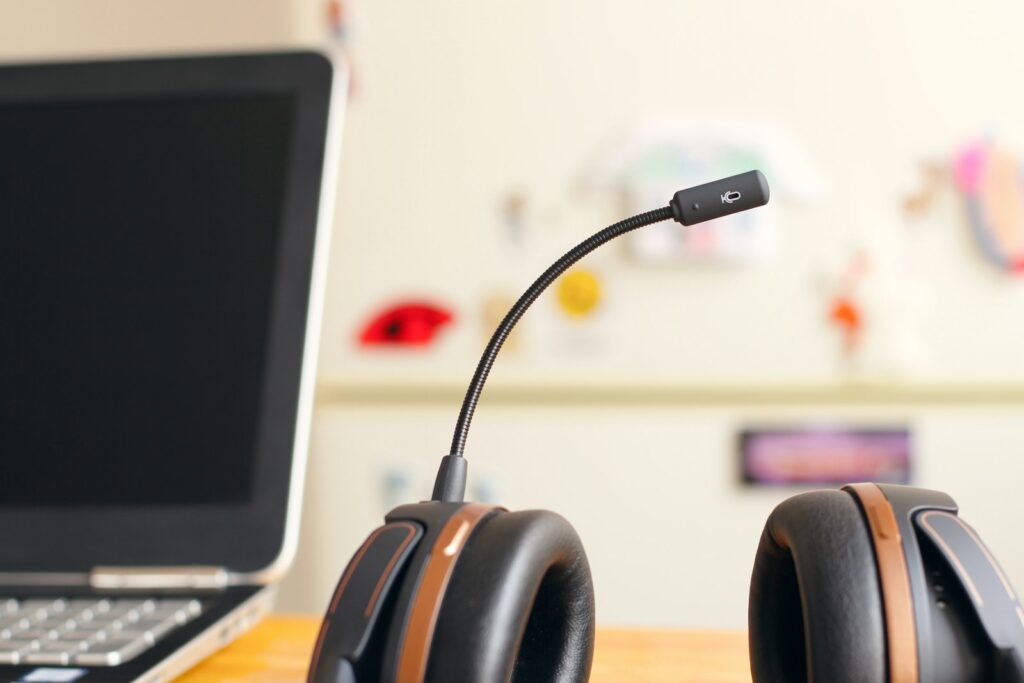 Headset with boom microphone next to a laptop, representing the Krisp app noise cancellation for video and voice calls